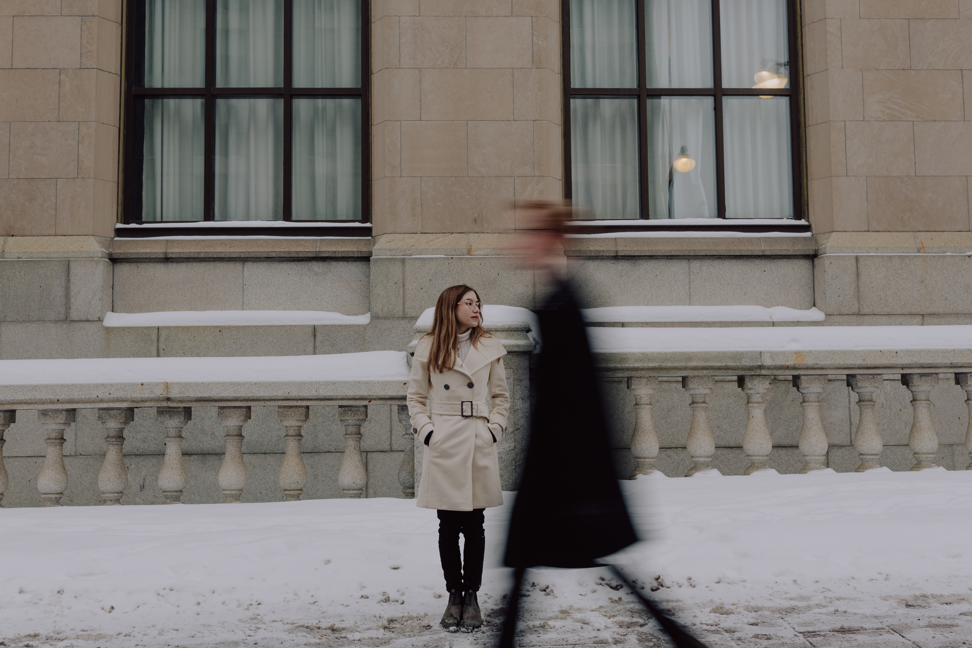 Kaitlyn in a cream coat outside a stone building in downtown Ottawa